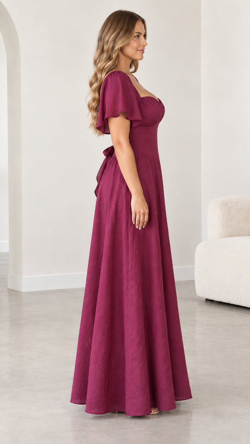 Side profile view of woman wearing magenta flutter sleeve A-line maxi dress