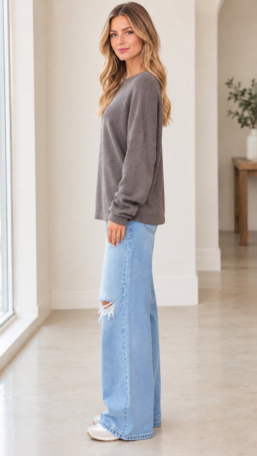 Side view of woman wearing charcoal grey long sleeve knit pullover sweatshirt