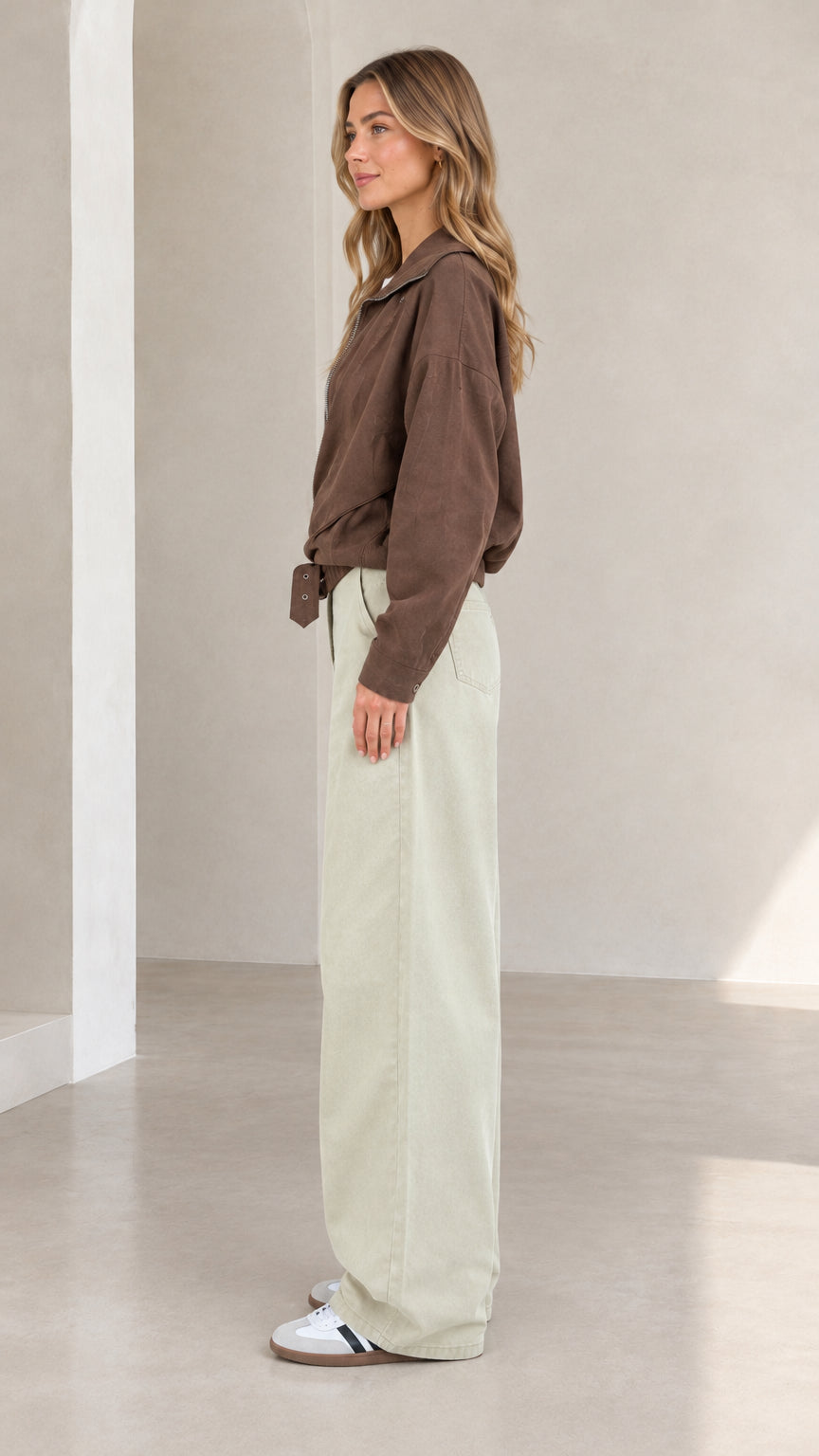 Side view of woman wearing brown utility jacket and relaxed wide-leg pants
