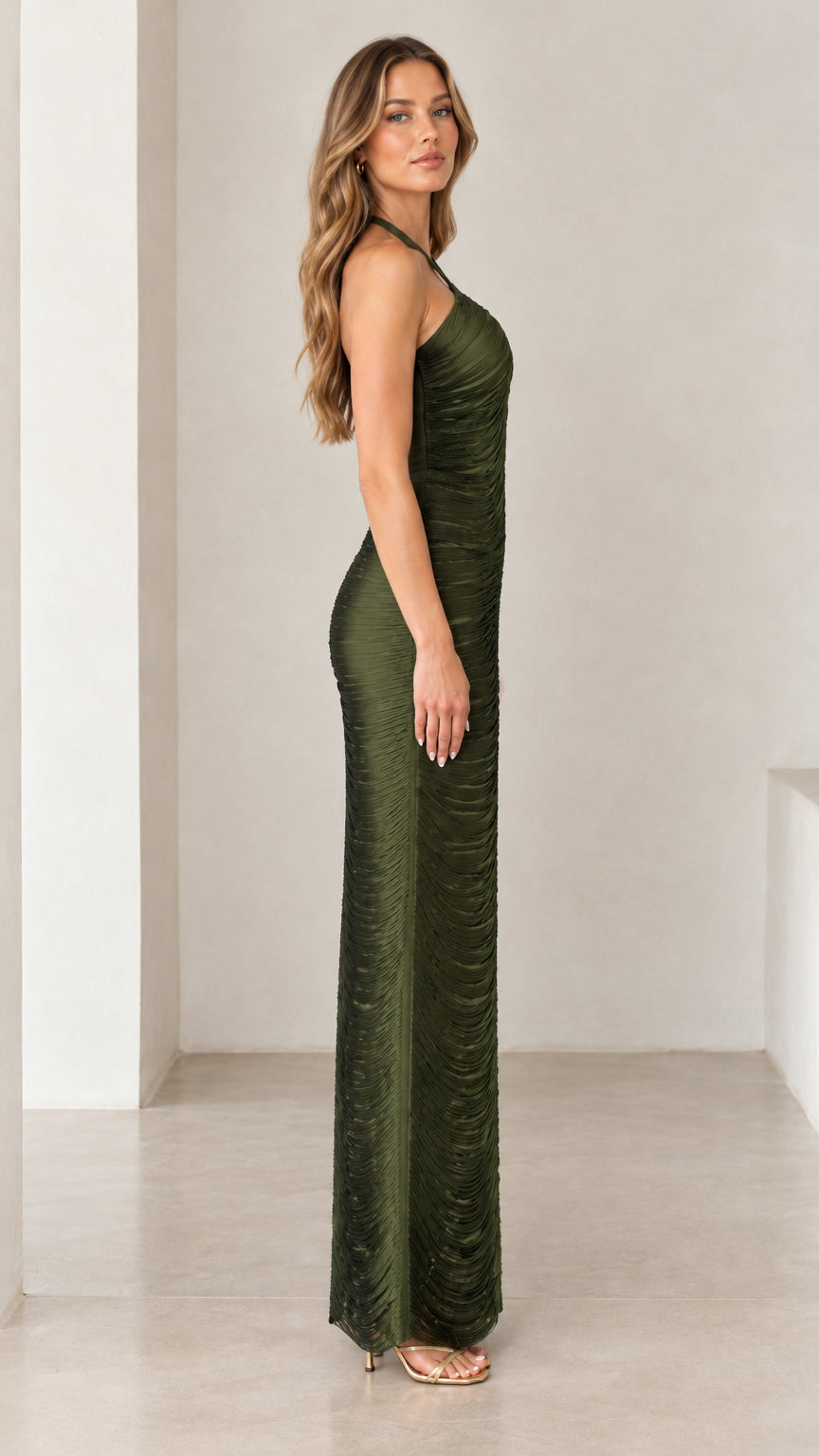 Side profile view of woman wearing olive green halter ruched column maxi dress