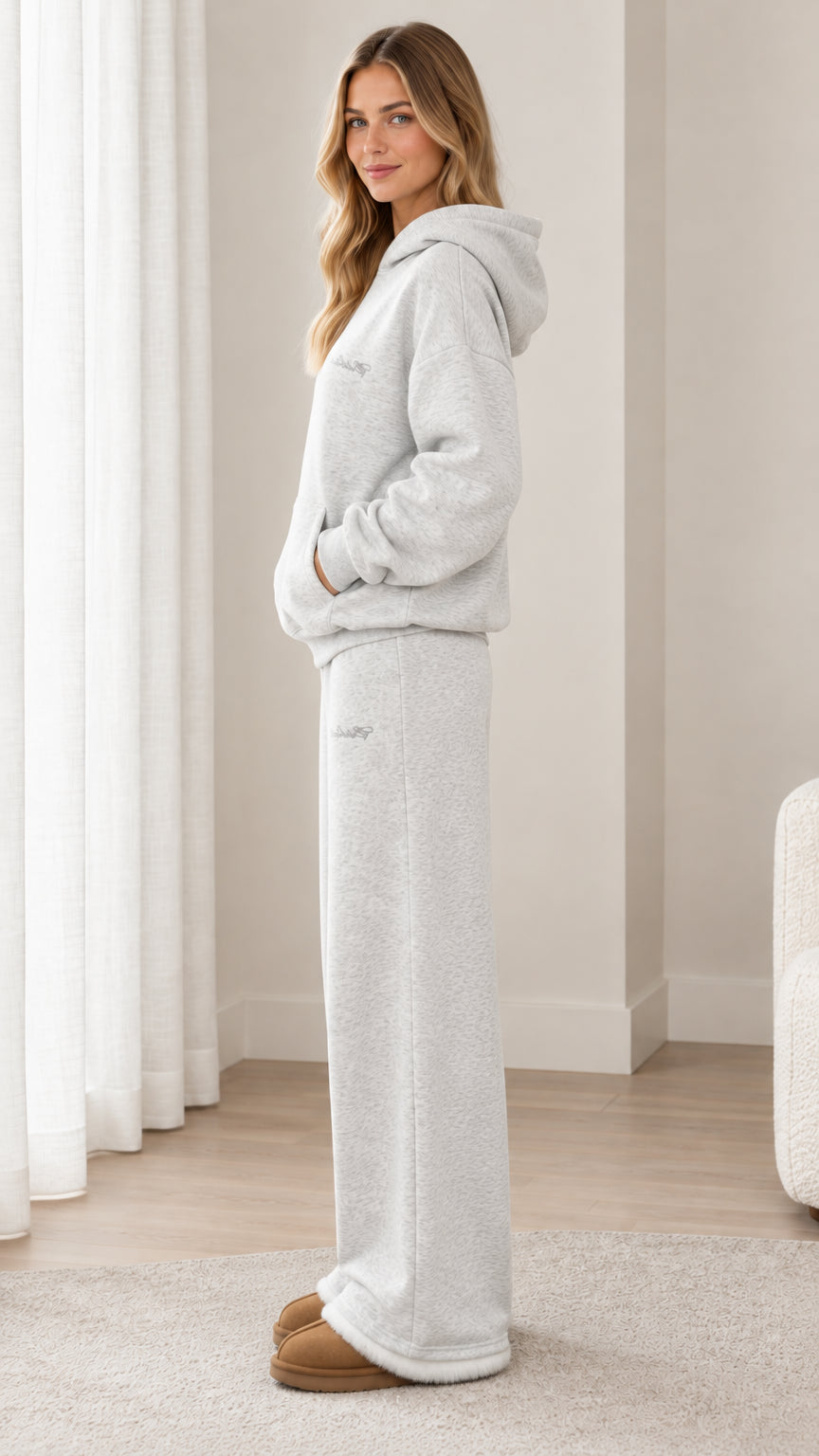 Side profile view of woman wearing light heather grey 2-piece hoodie and sweatpants lounge set