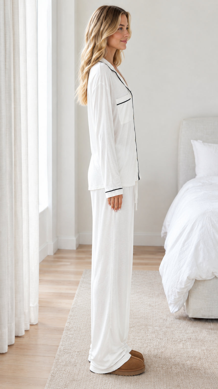 Side profile view of woman wearing white long sleeve pajama set with relaxed pants