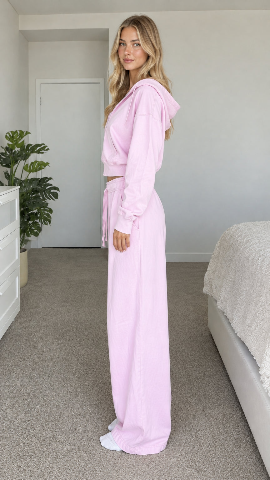 Side profile of model wearing light pink cropped zip-up tracksuit set