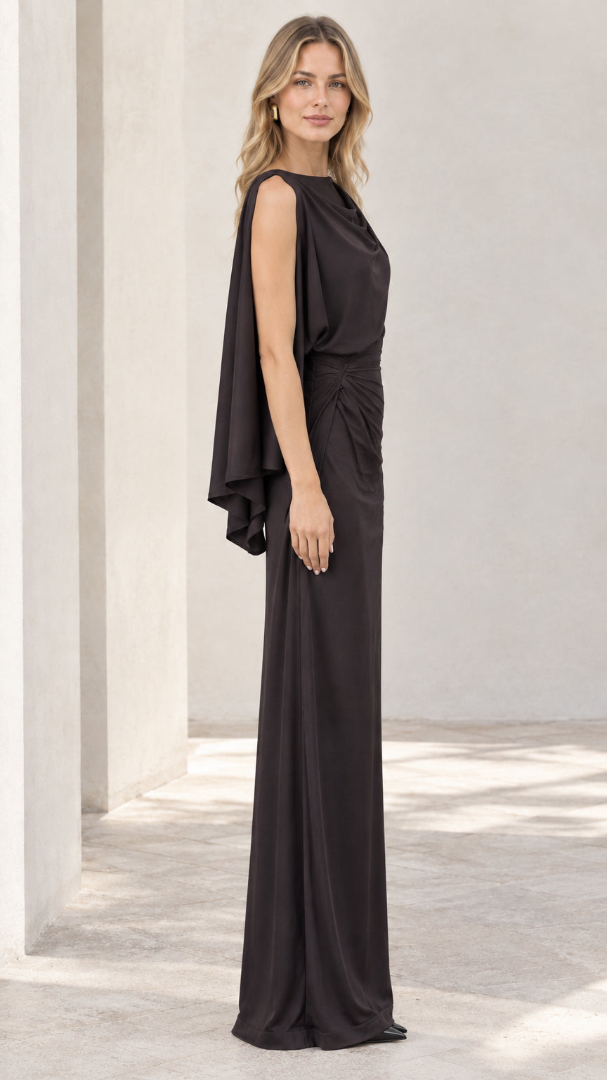 Side profile of black one-shoulder cape sleeve formal gown
