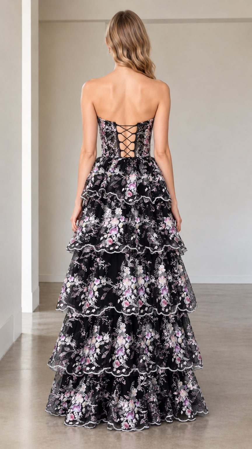 Back view of model showing lace-up corset detail on black floral tiered gown