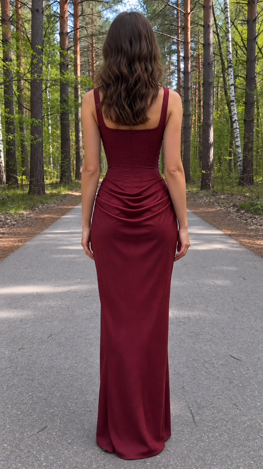 Back view of model wearing a burgundy square-neck maxi dress with ruched hip drape