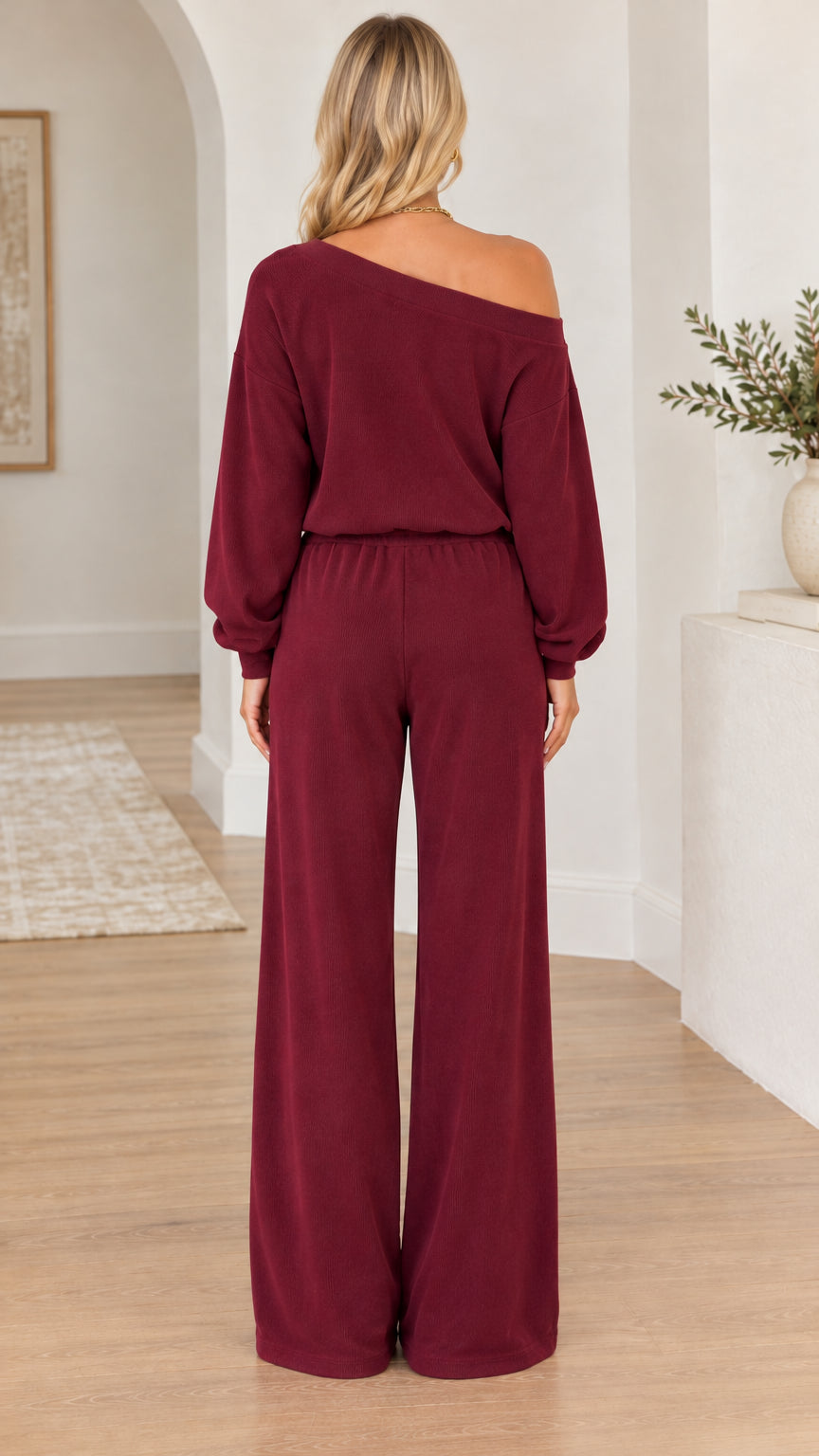 Back view of woman wearing the burgundy off-the-shoulder top and wide-leg pants