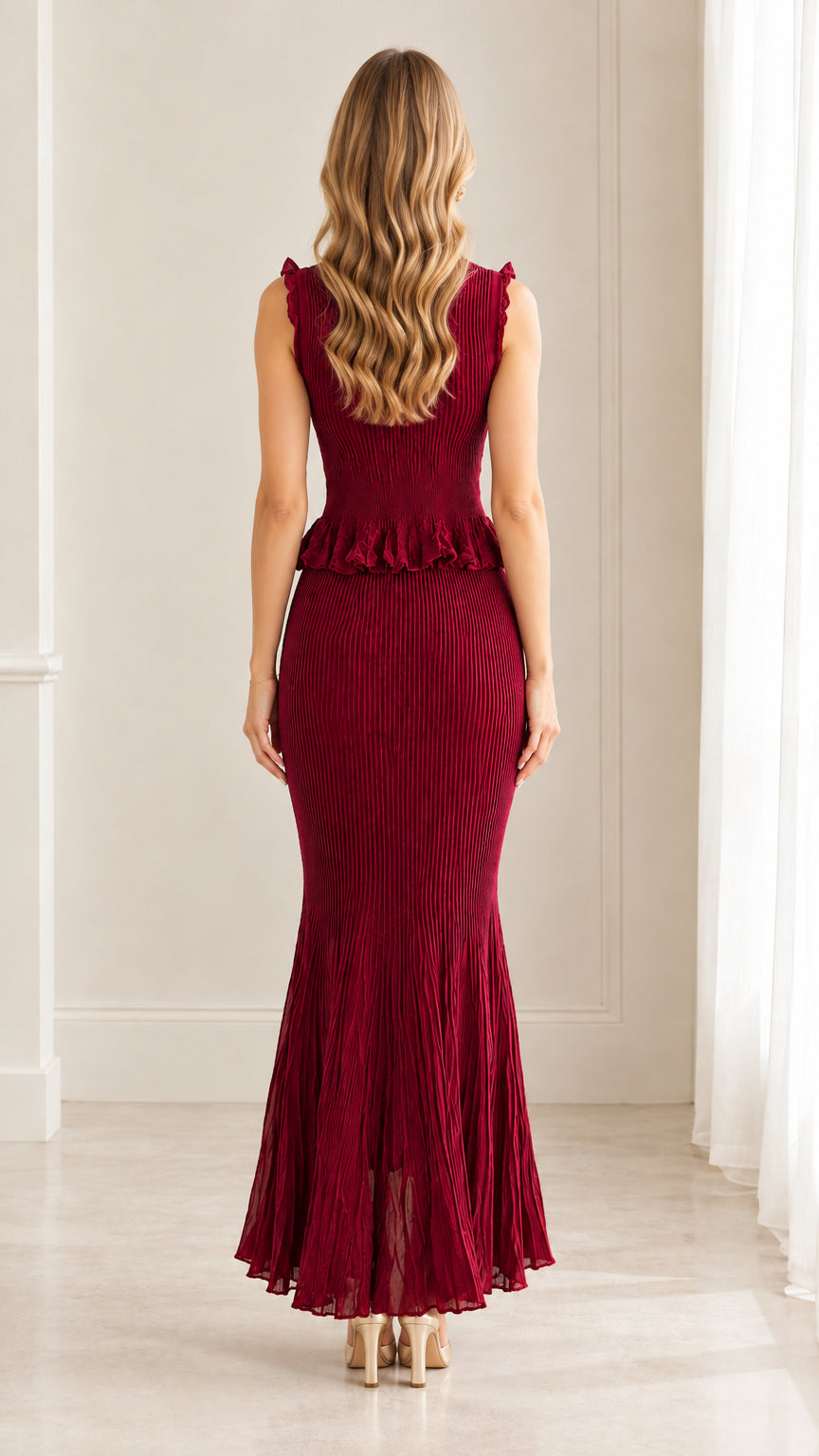 Back view of woman in wine red pleated peplum mermaid maxi dress