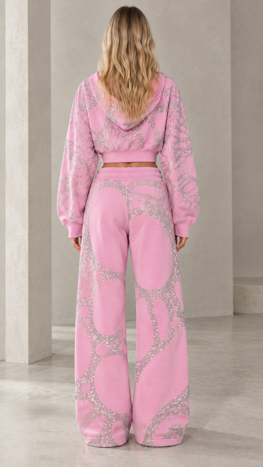 Back view of model wearing pink embellished hoodie and matching relaxed sweatpants