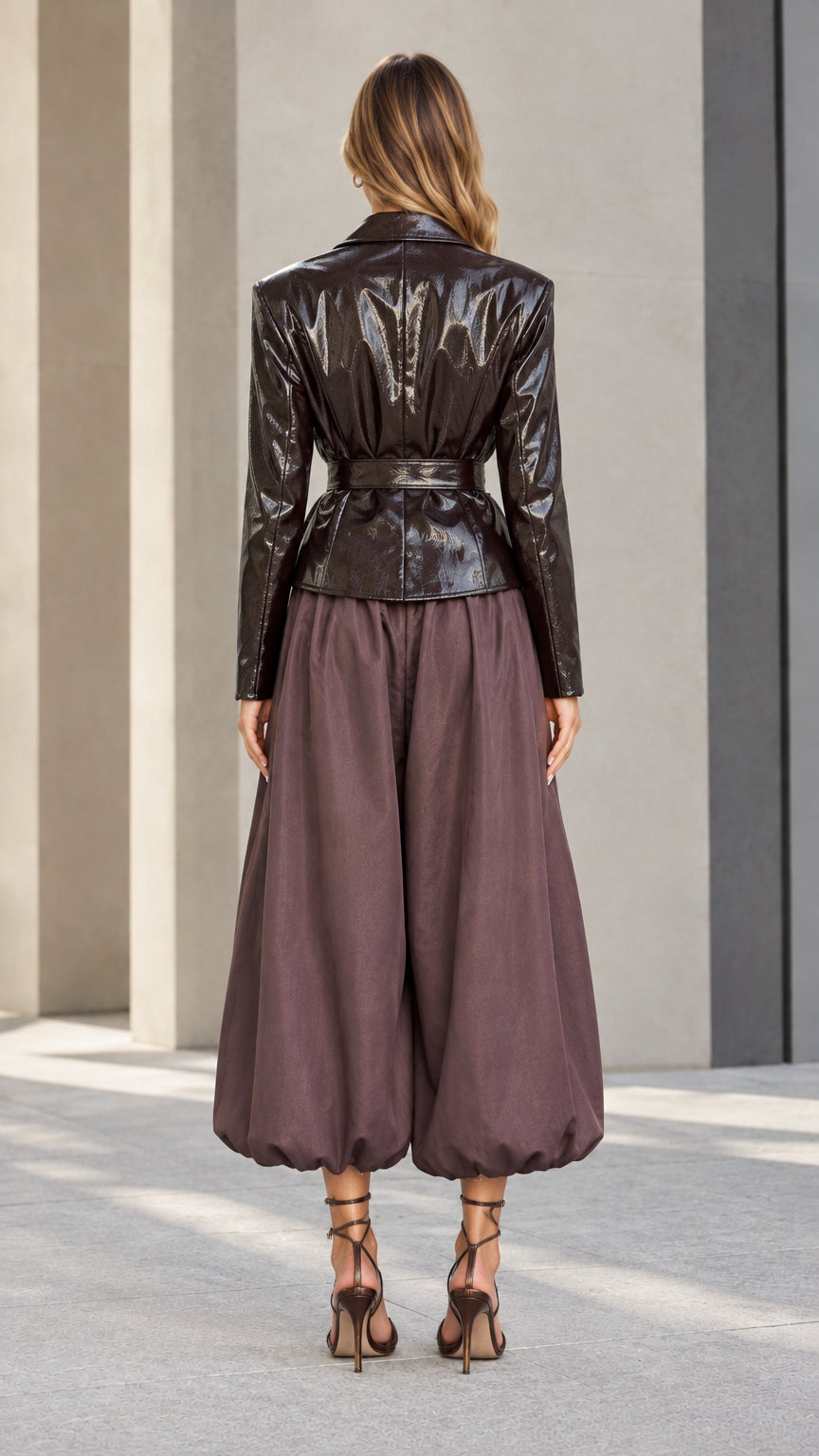 Back full-length view of model in chocolate brown high-shine belted blazer and culotte pants