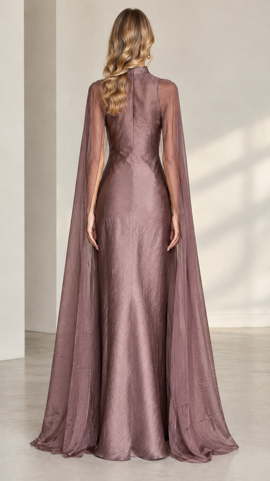 Back full-length view of dusty mauve gown showing flowing cape train and fit