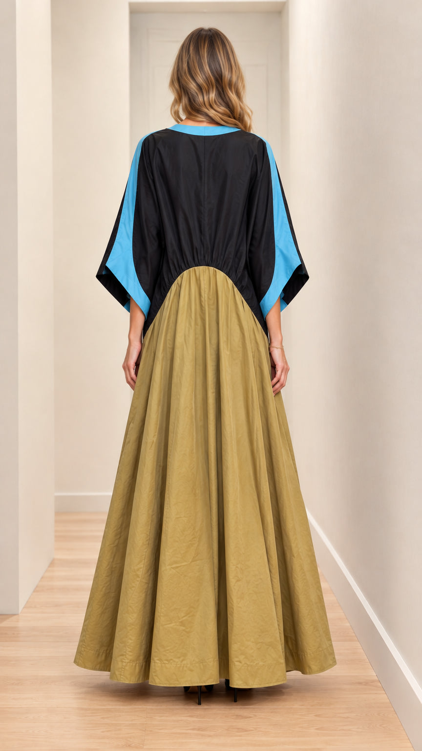 Back full-length view of model wearing black and khaki flowing maxi dress