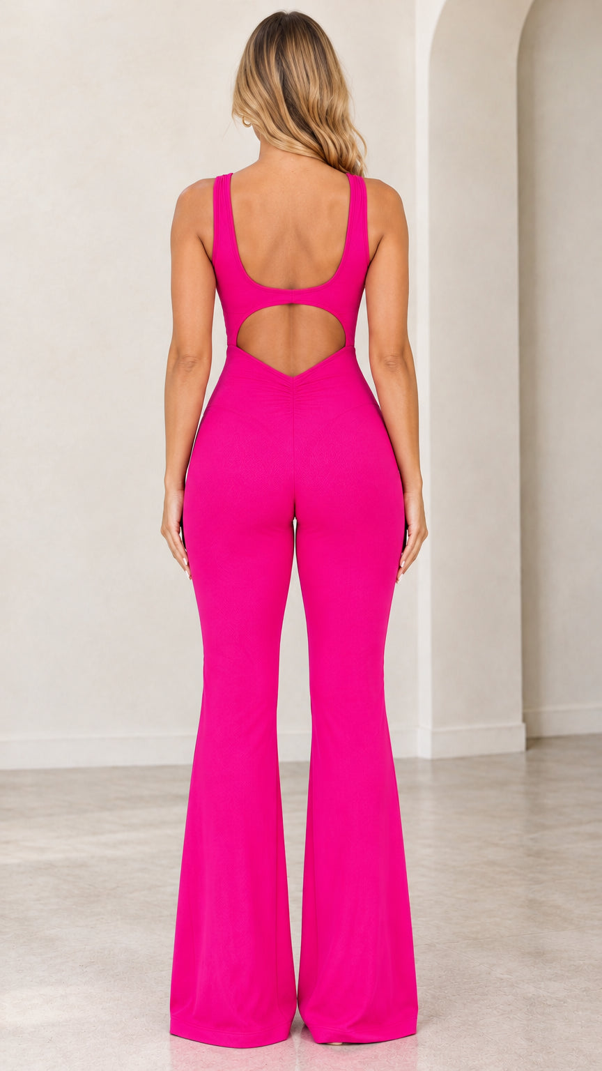 Back view of model showing open cutout back and ruched detail on hot pink flare jumpsuit