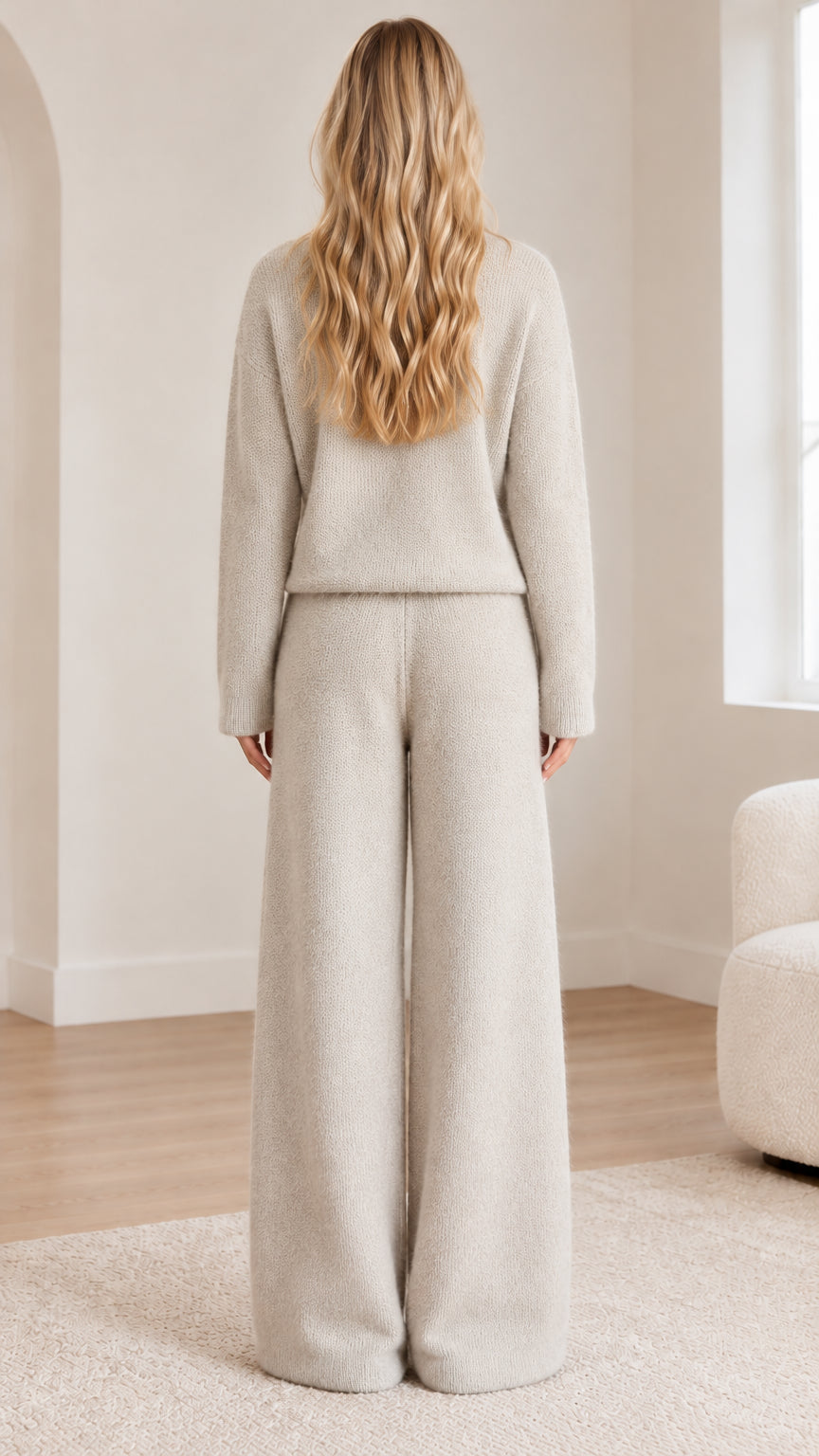 Back view of woman wearing matching oatmeal knit crewneck sweater and lounge pants