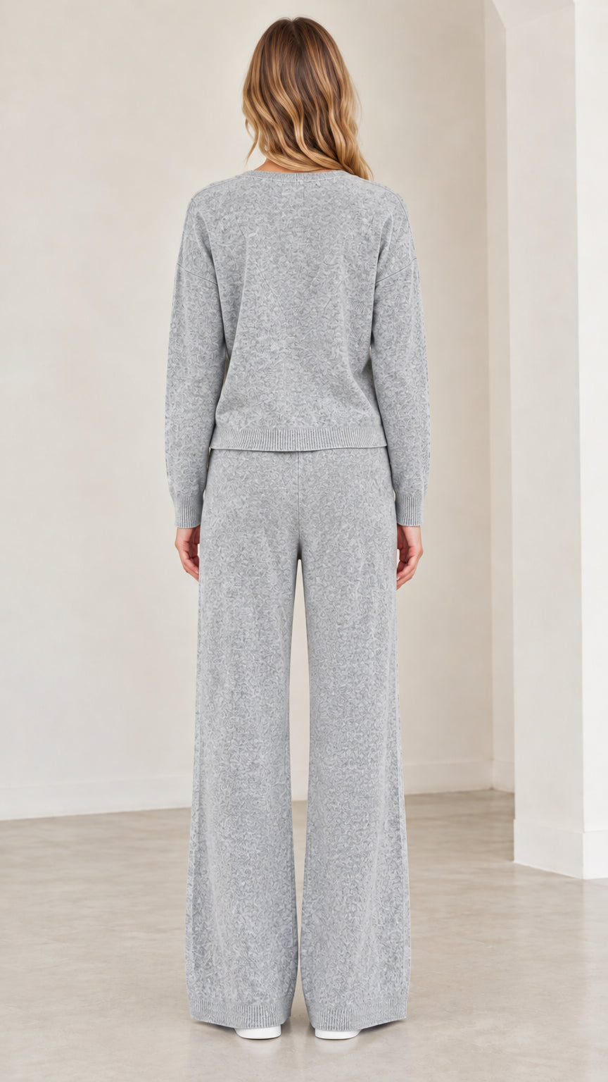 Back full view of woman wearing grey knit cardigan and wide leg pants set