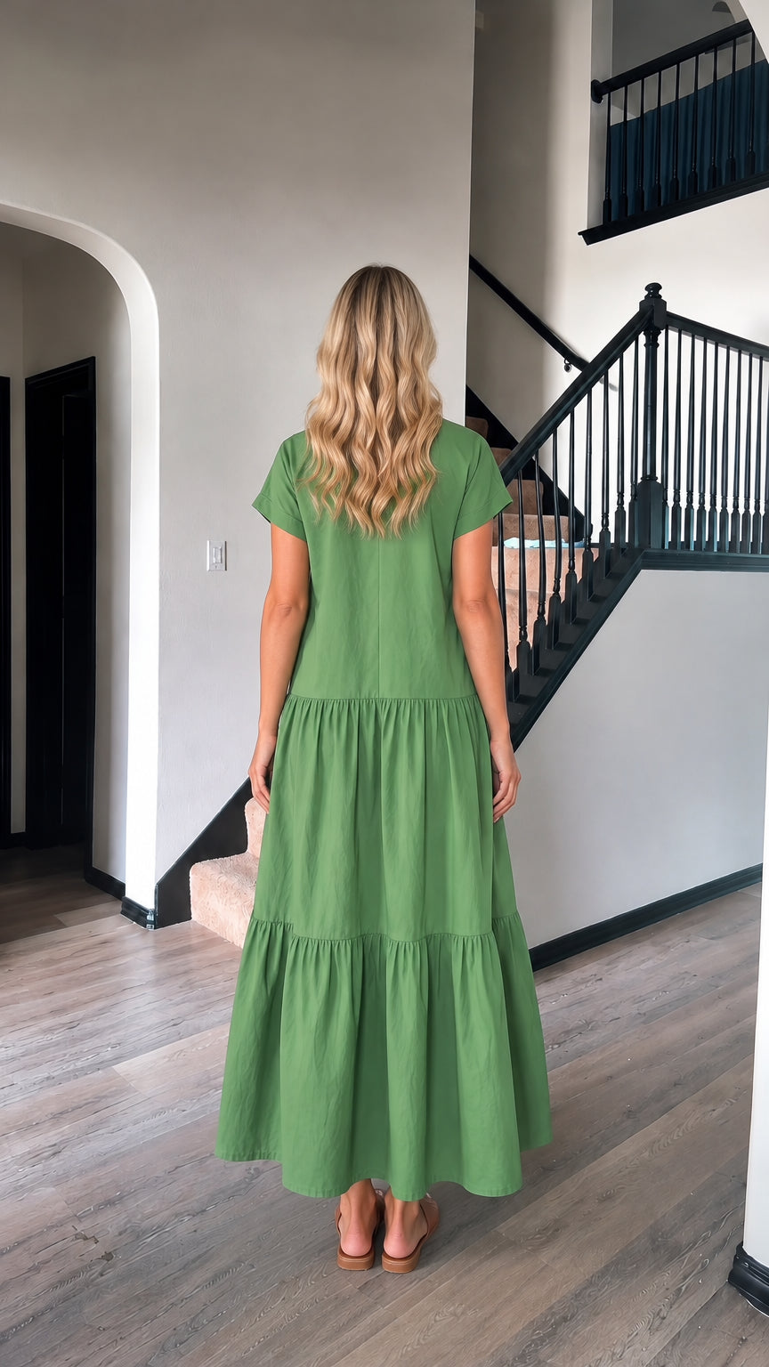Back full-length view of woman in green loose fit tiered maxi dress