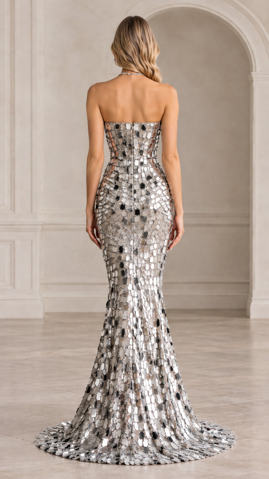 Back view of woman wearing silver strapless sequin mermaid evening gown