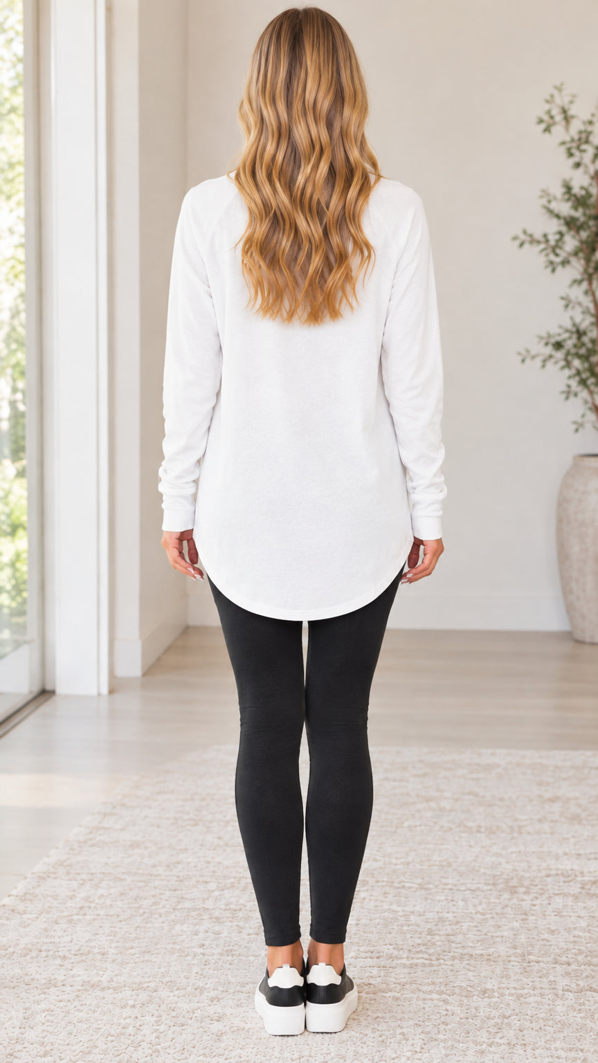 Back view of the white long sleeve tunic top displaying length and hip coverage