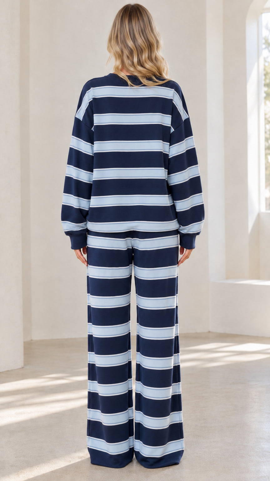 Back view of model wearing Navy Blue striped long-sleeve top and matching wide-leg pants