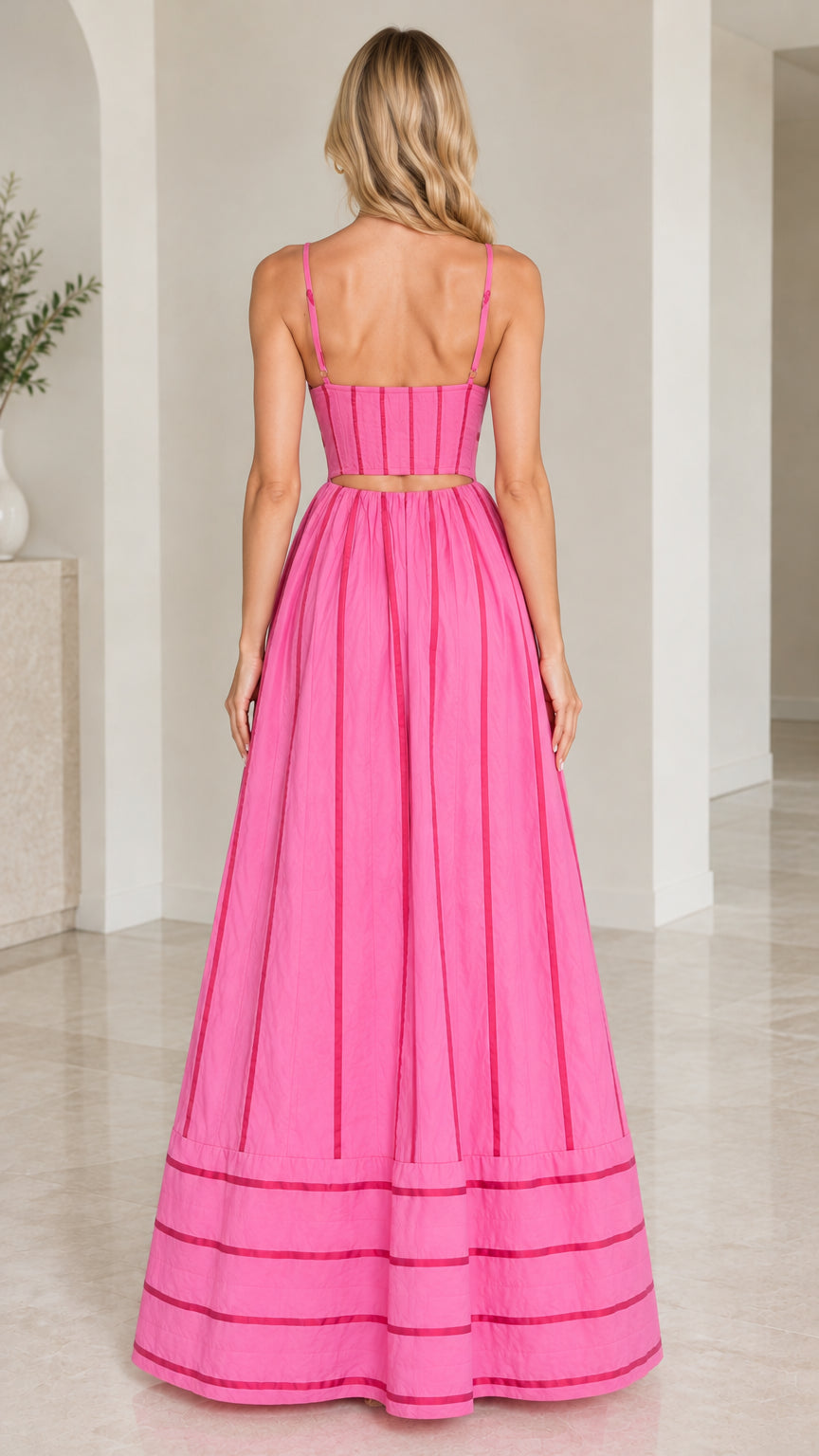 Rear view showing cutout back design and paneled corset styling on hot pink maxi dress