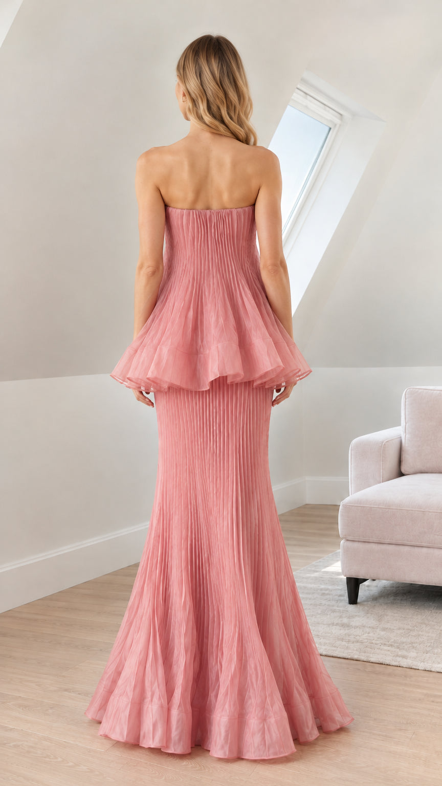 Back view of woman wearing dusty rose strapless pleated maxi gown