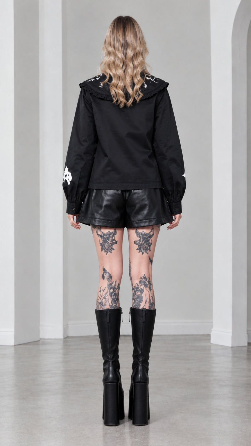 Back view of model wearing black gothic blouse highlighting the wide statement collar and smooth silhouette
