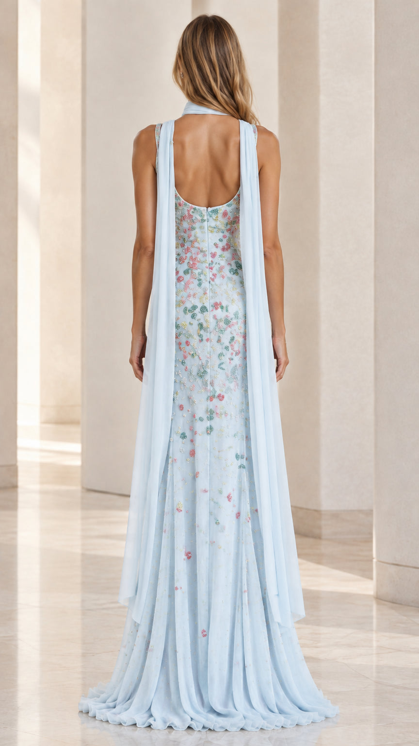 Back view of model displaying the low back neckline and trailing chiffon cape scarf streamers