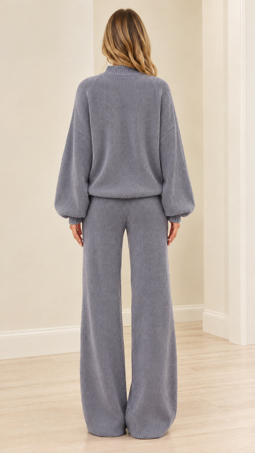 Back view of woman wearing dusty blue ribbed knit sweater and wide-leg trousers