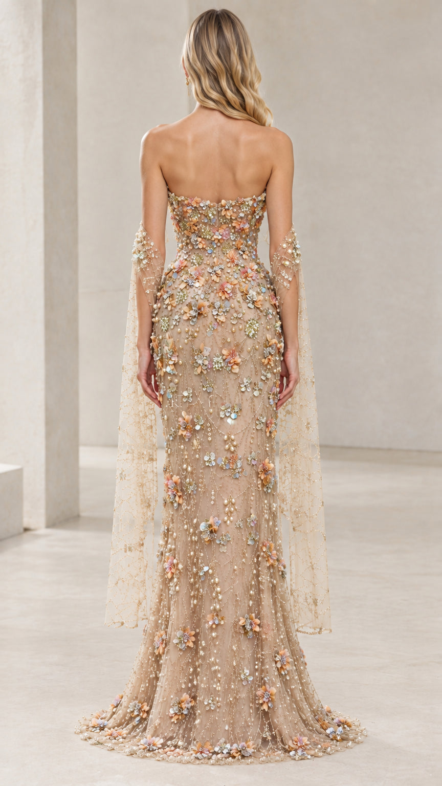 Back view of champagne strapless embroidered evening gown with delicate tulle drapery
