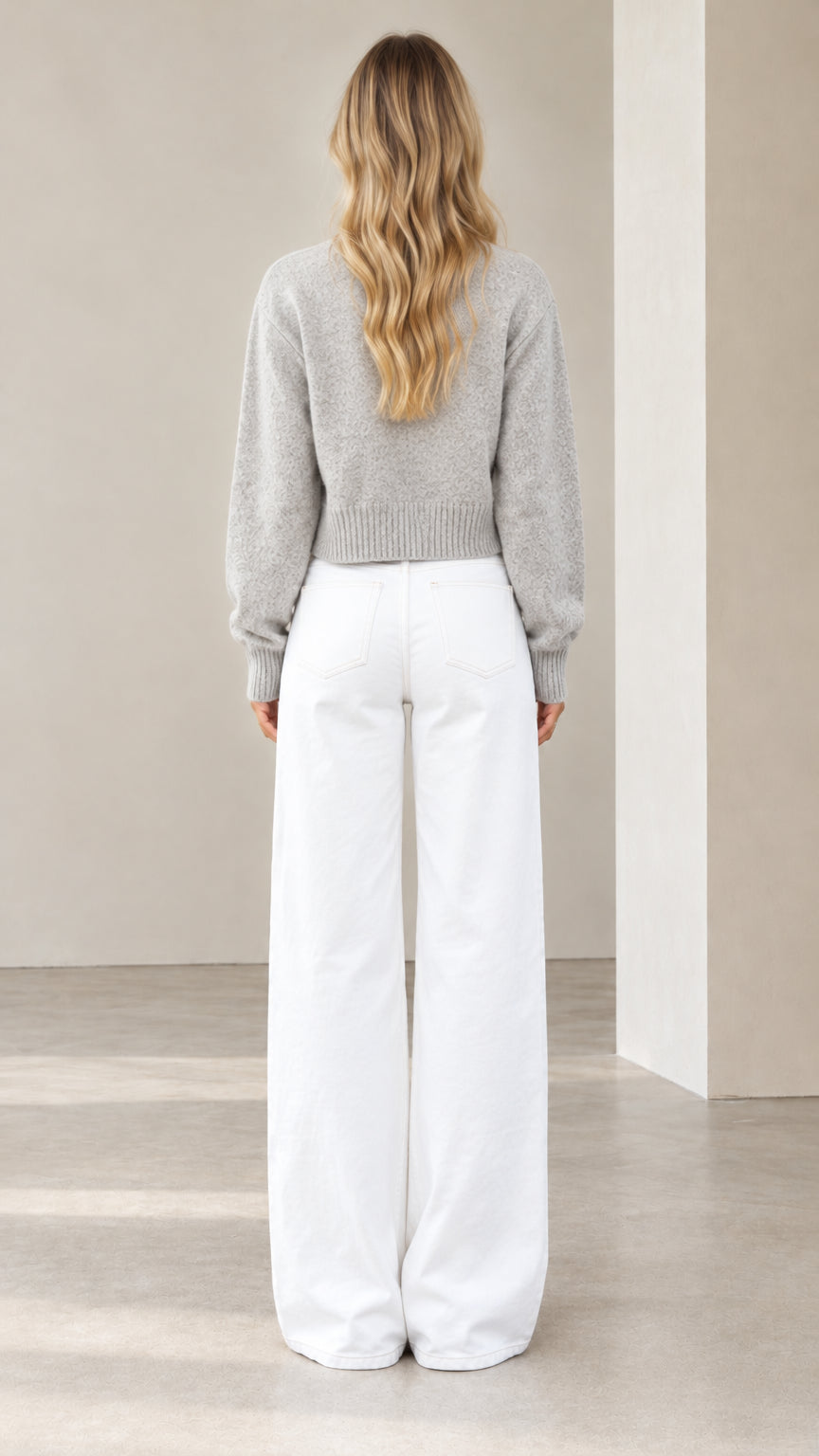 Back view of model wearing a heather grey cropped knit sweater showing drop shoulder silhouette