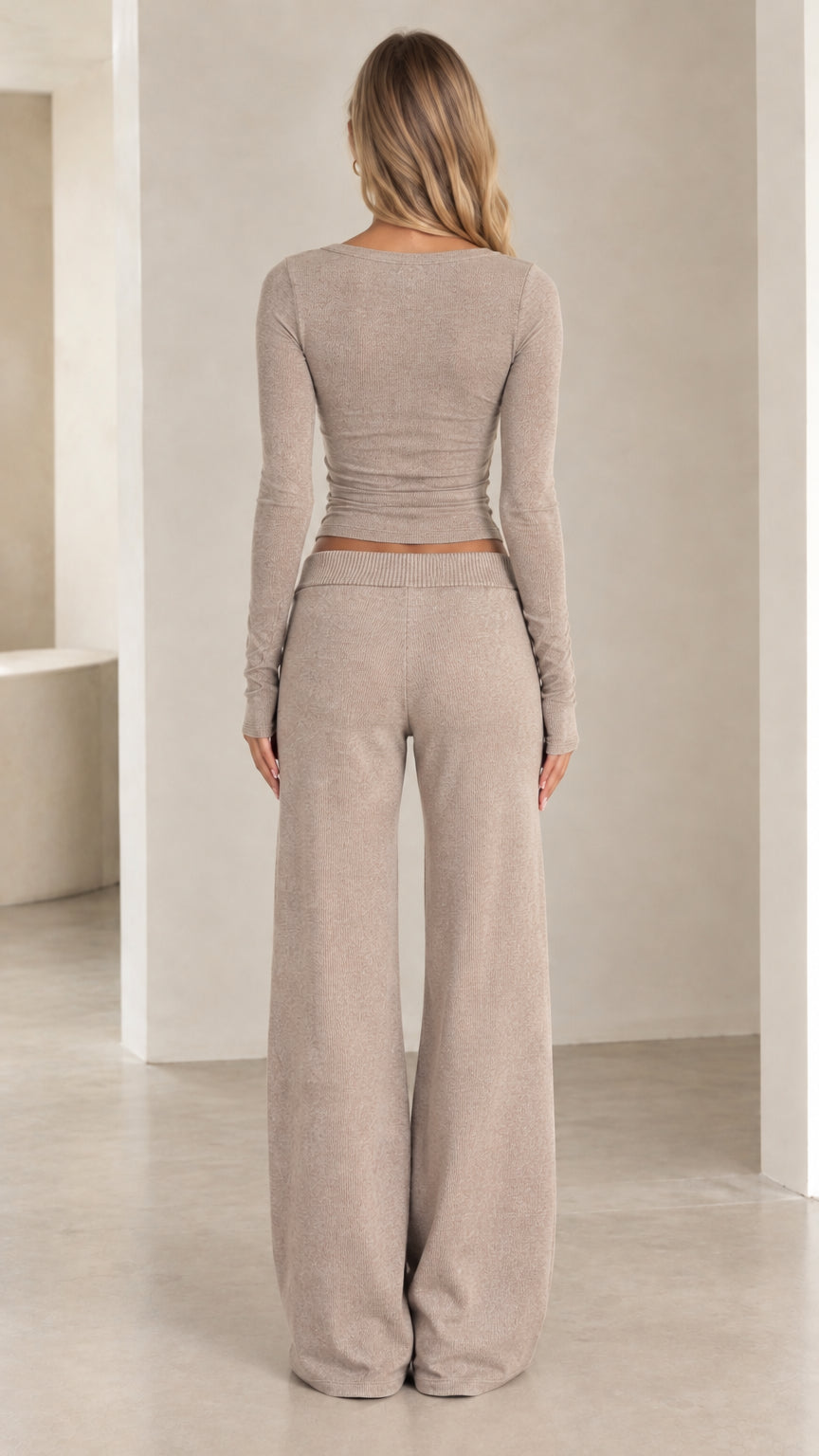 Back view of model wearing beige ribbed knit top and wide-leg drawstring pants