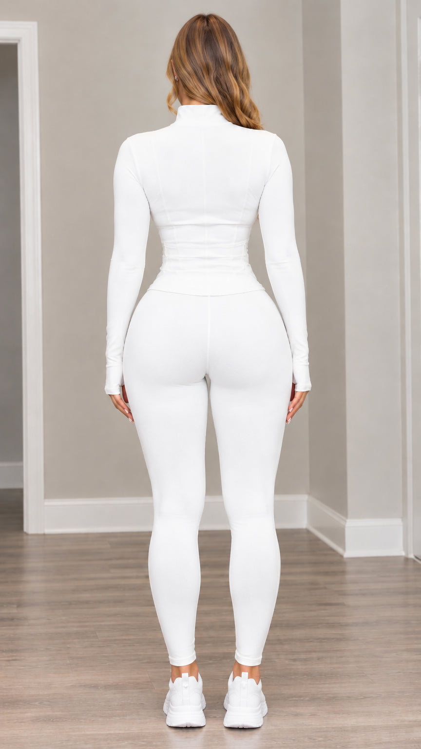 Rear view of model wearing white athletic jacket with contoured seams and matching leggings