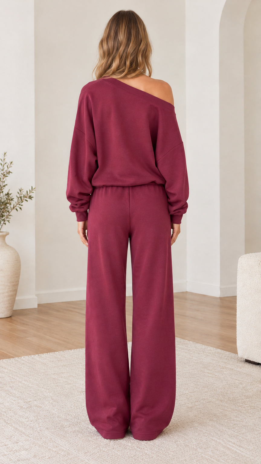 Back view of model wearing burgundy off-the-shoulder sweatshirt and wide-leg pants