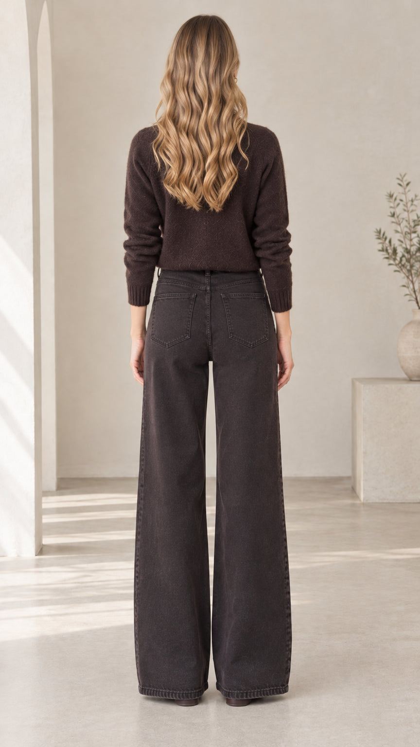 Back view of woman wearing dark brown collared button-down knit cardigan