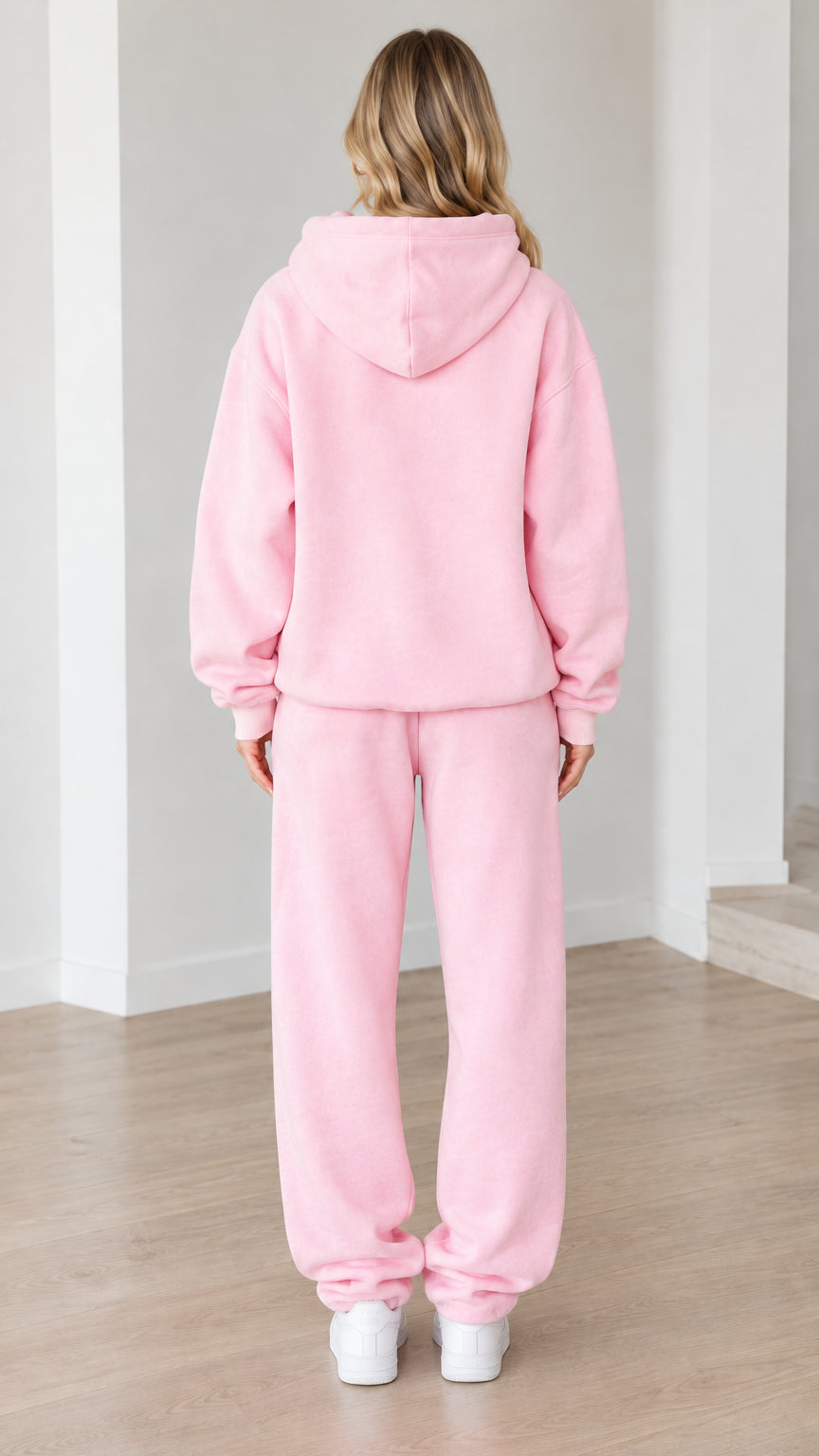 Back view of woman wearing the pink hoodie and jogger pants matching set