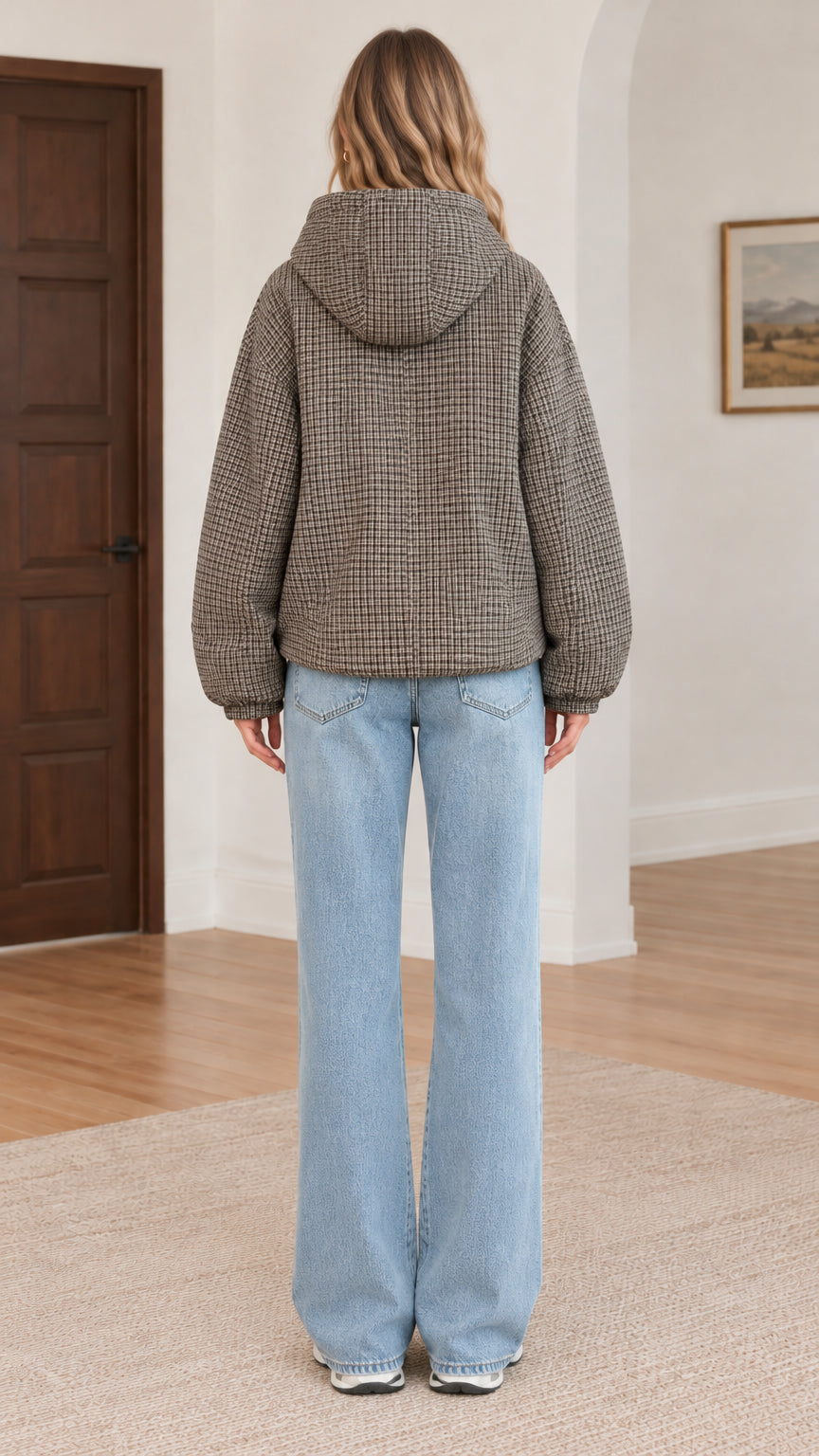 Back view of model wearing brown houndstooth hooded winter jacket