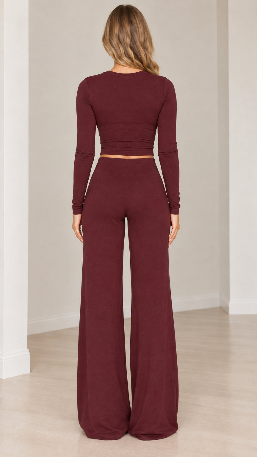Back view of women's burgundy long sleeve crop top and matching wide leg trousers