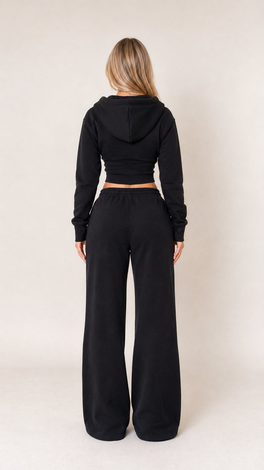 Back view of model wearing black cropped hoodie and wide leg sweatpants set