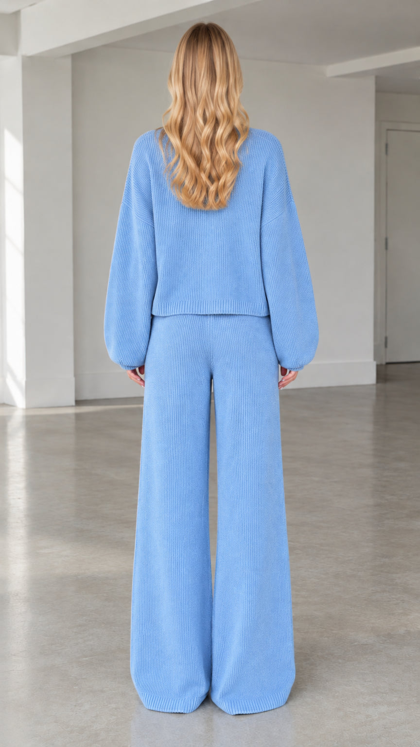 Back full view of woman wearing light blue ribbed knit jacket and wide-leg pants set