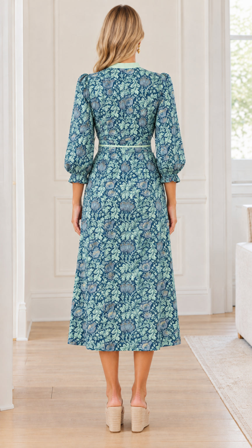 Back full view of teal blue floral print midi dress showing skirt drape and gathered sleeves