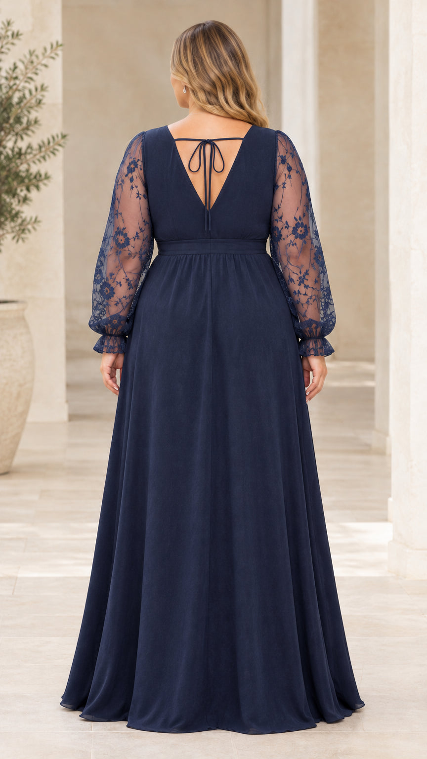 Back view of navy blue evening gown highlighting deep back V and tie accent