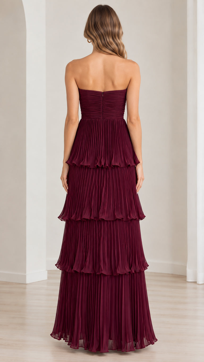Back view of model in burgundy tiered pleated maxi dress showing zip closure