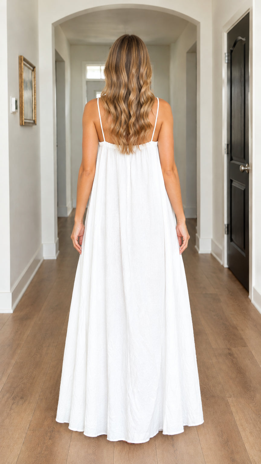 Back view of model wearing white sleeveless maxi dress with thin straps