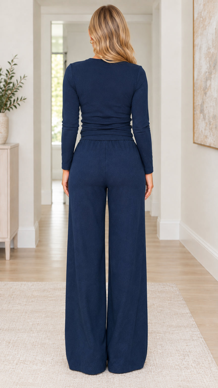 Back view of woman wearing navy blue long sleeve top and wide leg trousers set
