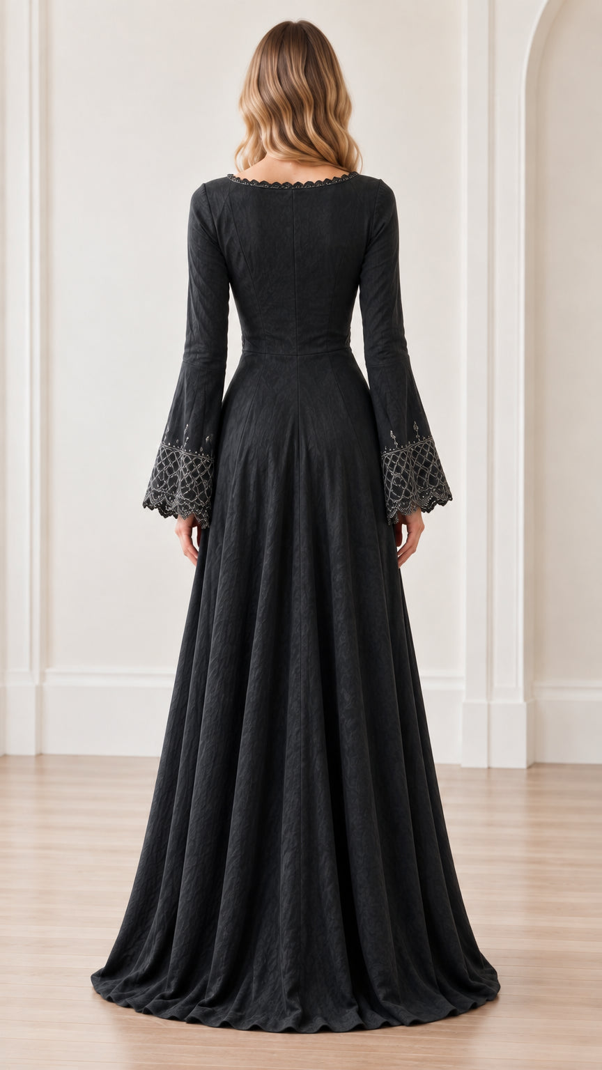 Back full-length view of woman wearing black maxi dress showing flowing skirt and draped sleeves