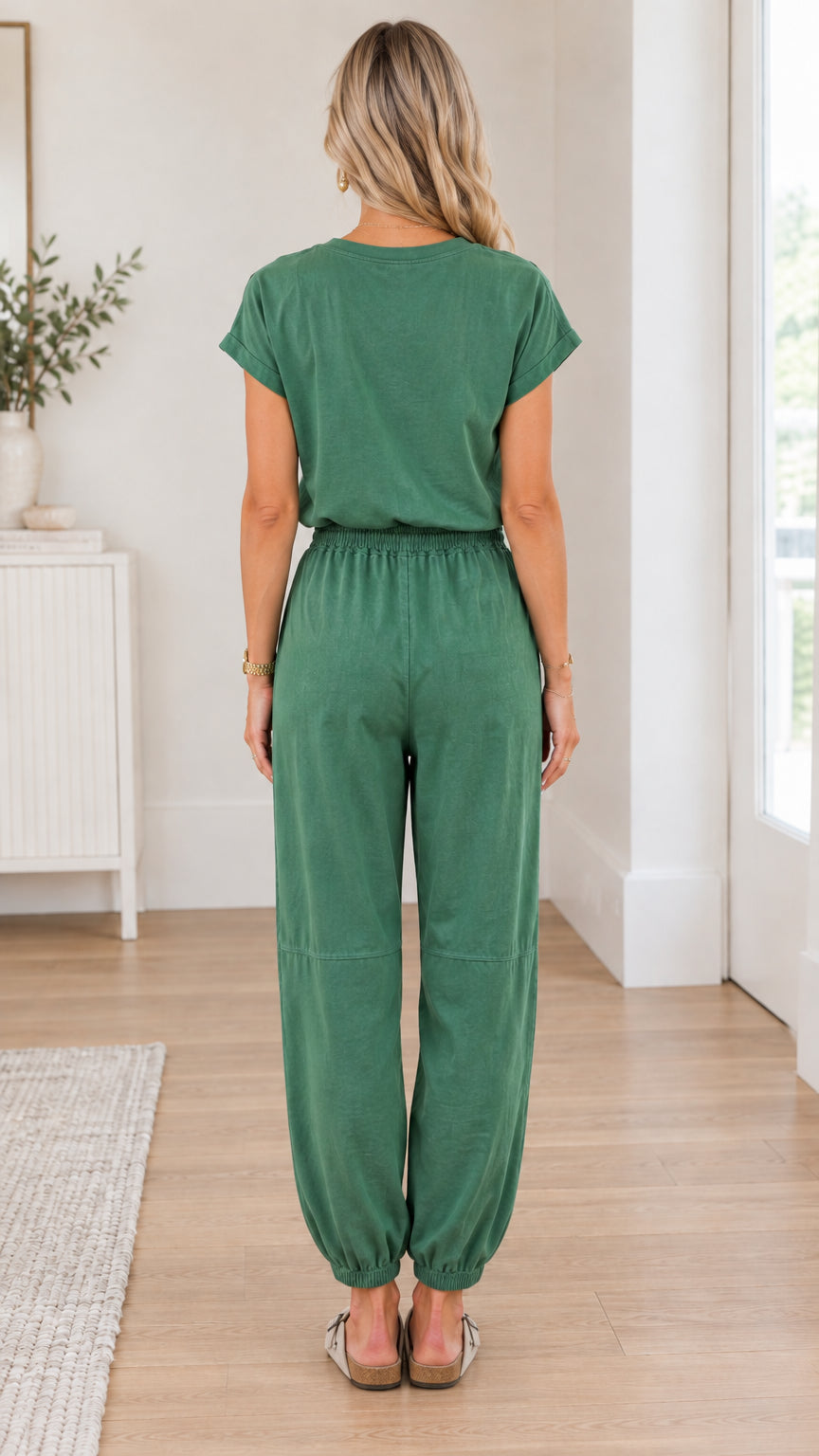 Back full view of woman wearing green short sleeve drawstring jogger jumpsuit