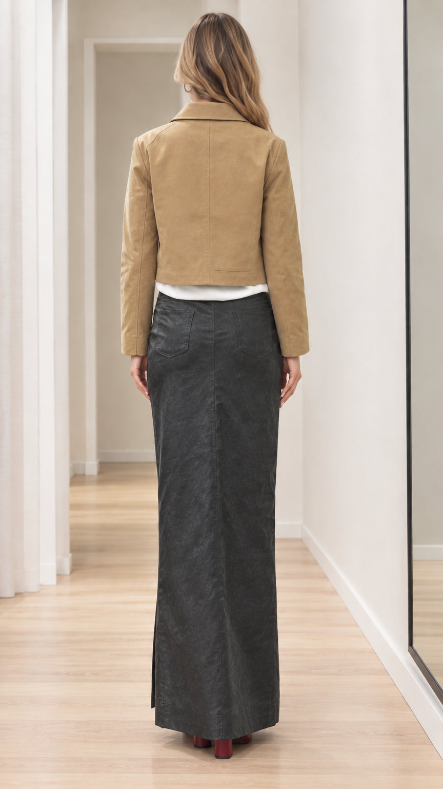Back view of woman wearing tan cropped jacket showing structured clean hemline