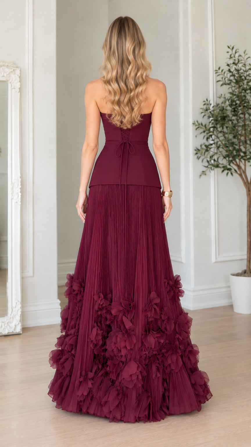 Back view of burgundy formal maxi dress showcasing lace-up corset back detail and floor-length pleated skirt