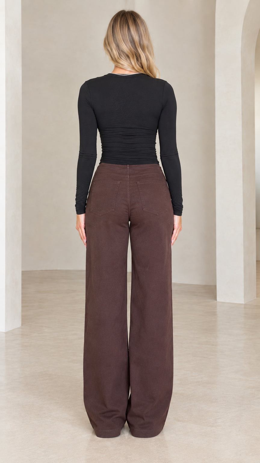 Back view of model wearing long sleeve top and chocolate brown wide leg pants