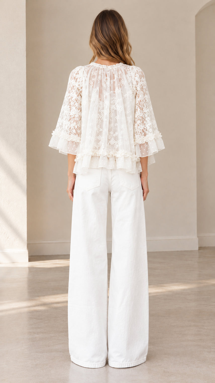 Back full-body view of model in white floral lace blouse highlighting keyhole neck detail